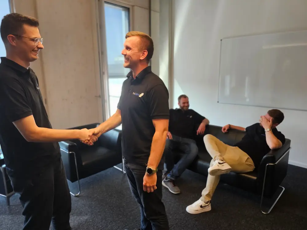 Kollegen im Gespräch und zwei geben sich die Hand